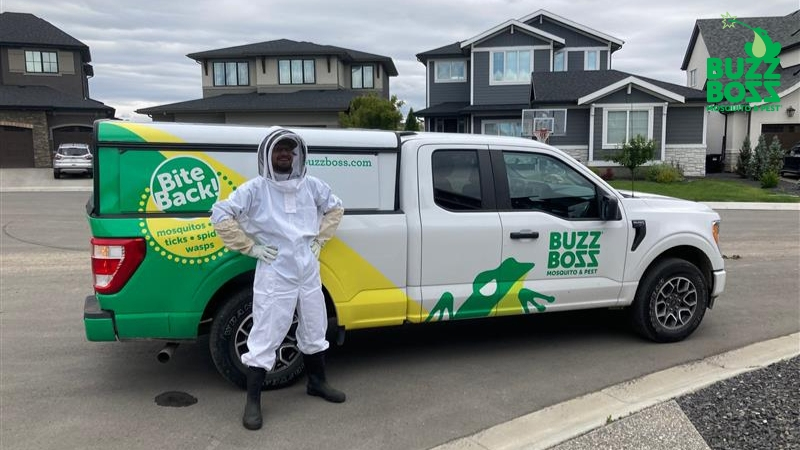 Buzz Boss worker in front of a company spray truck
